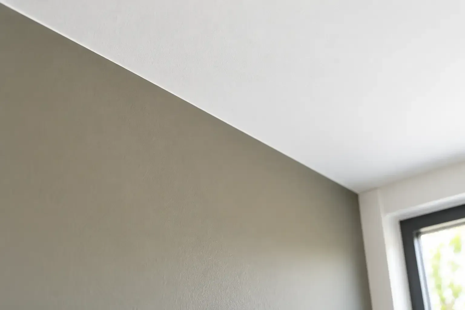 Strakke overgang tussen een gekleurde wand en een wit plafond.